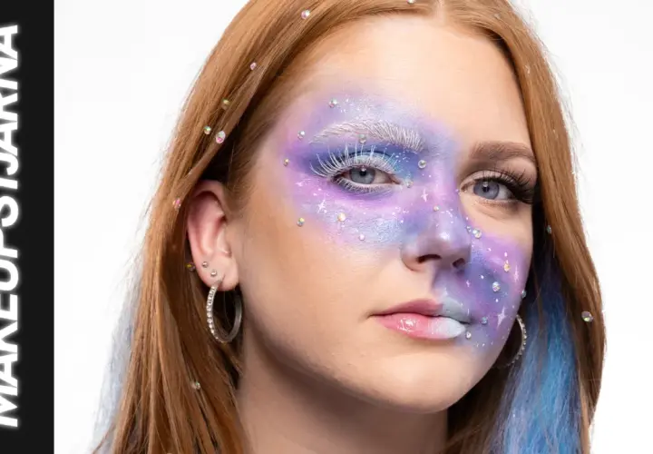 En ung kvinna med fantasifull sminkning i lila och blått, inspirerad av 60 tals smink. Glitter och stenar pryder ansiktet.