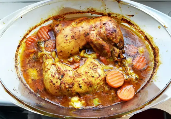 Pieczone udka z kurczaka w aromatycznej marynacie, z marchewką i brokułami, w szklanym naczyniu.