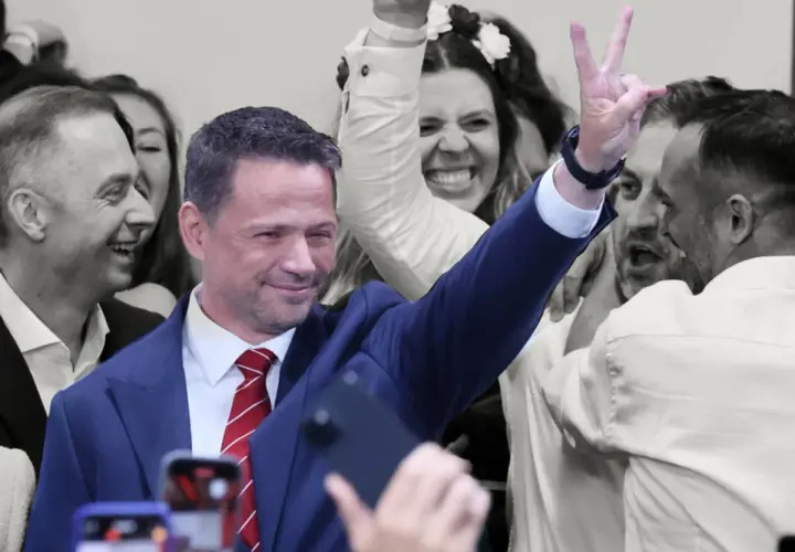 Karol Nawrocki z uśmiechem i gestem zwycięstwa, otoczony entuzjastycznym tłumem. To obraz, który może sugerować, dlaczego Karol Nawrocki wygrywa w najnowszych sondażach prezydenckich z marca 2026.