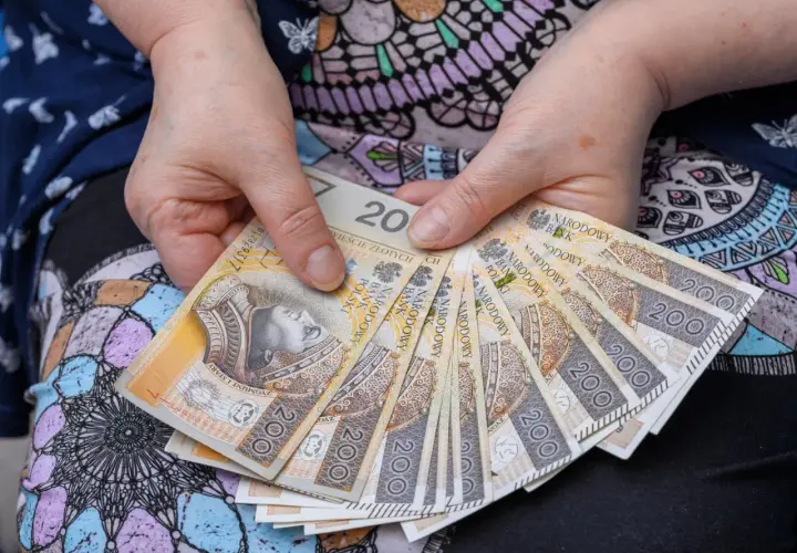Dłonie trzymające banknoty 200 zł. Może to być zapowiedź wypłaty bonu senioralnego 2026.