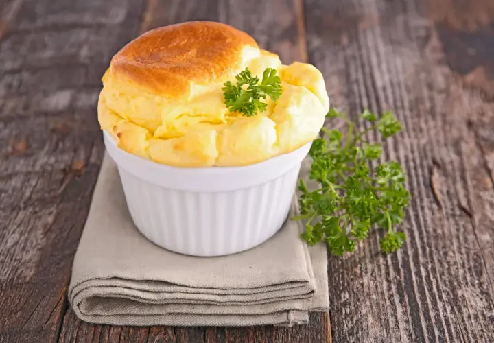 Un soufflé salé doré et aérien, garni de persil frais, parfait pour une recette de soufflé salé facile.