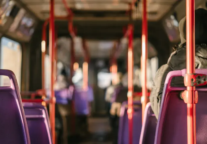 Wnętrze autobusu relacji Sanok-Wetlina. Fioletowe siedzenia i czerwone poręcze tworzą charakterystyczny widok.