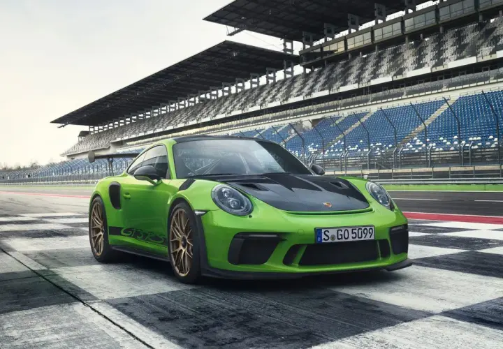 Zielony Porsche 911 GT3 RS na torze wyścigowym. Sprawdź porsche 911 gt3 rs cena i poczuj moc!