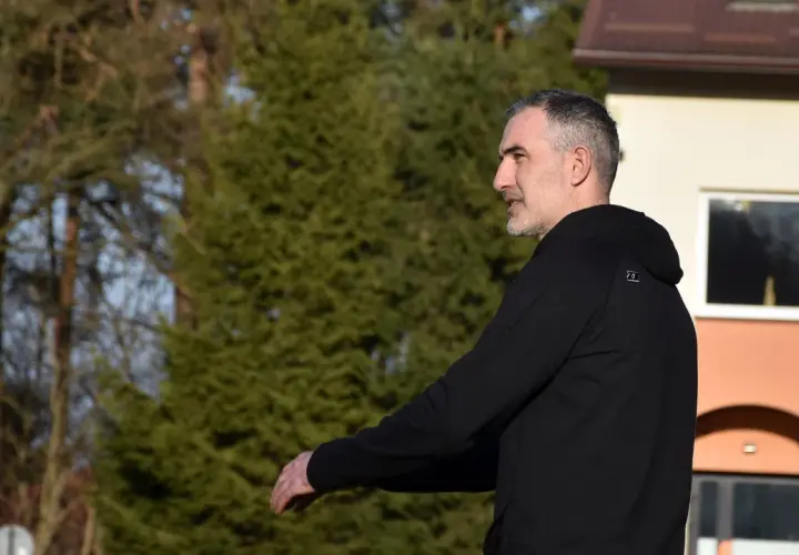 Szeliga trener w czarnej bluzie, z uwagą obserwuje boisko.