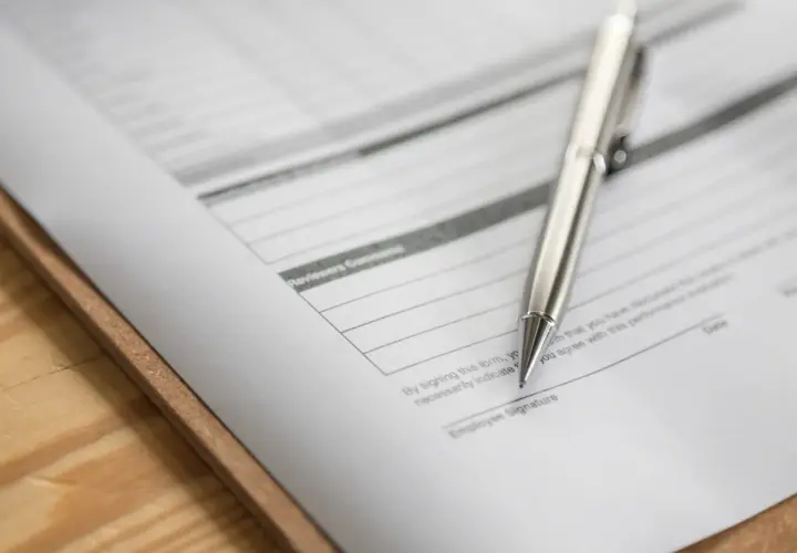 Srebrny długopis leży na dokumencie z polem "Employee Signature". To zap-3, gotowy do podpisu.