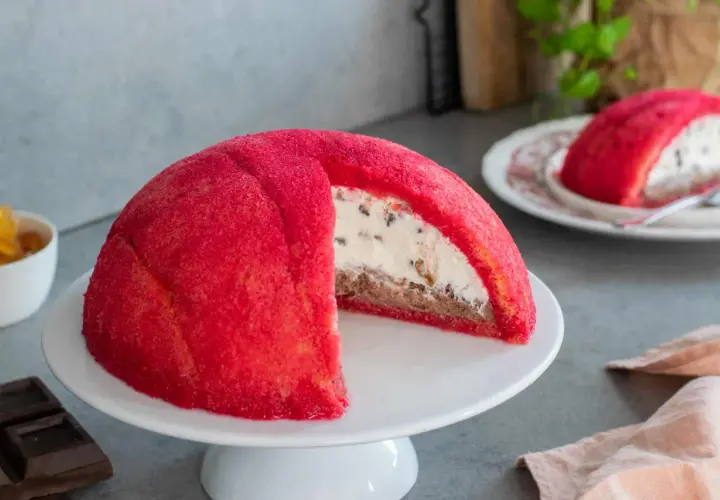 Un invitante zuccotto semifreddo, con la sua cupola rossa brillante e un cuore cremoso e goloso.