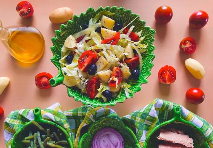 Deliziosa insalata di patate napoletana con pomodorini, olive e lattuga, condita con olio d'oliva.