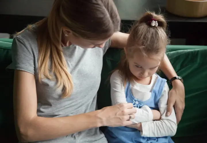 Madre intenta consolar a su hija, que se muestra enfadada y con los brazos cruzados. Un momento difícil cuando un hijo trata mal a su madre.
