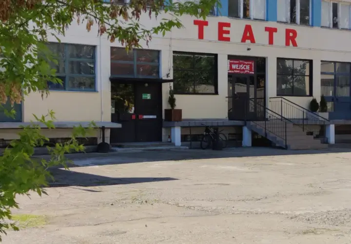 Teatr Druga Strefa. Budynek z czerwonym napisem "TEATR" na fasadzie, wejście z wielojęzycznym napisem "WEJŚCIE".