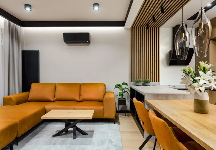 Pomarańczowa kanapa i krzesła tworzą przytulny salon inspiracje. Drewniane elementy i nowoczesne oświetlenie dodają elegancji.