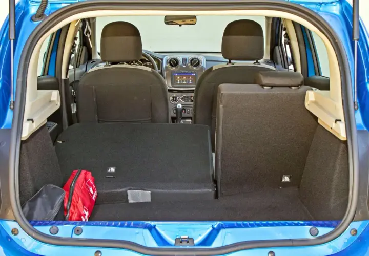 Bagażnik Dacia Sandero, gotowy na podróż. Widoczna apteczka i torba.