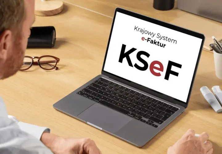 Mężczyzna pracuje przy laptopie z logo KSeF. Ułatwia to księgowanie faktur kosztowych.