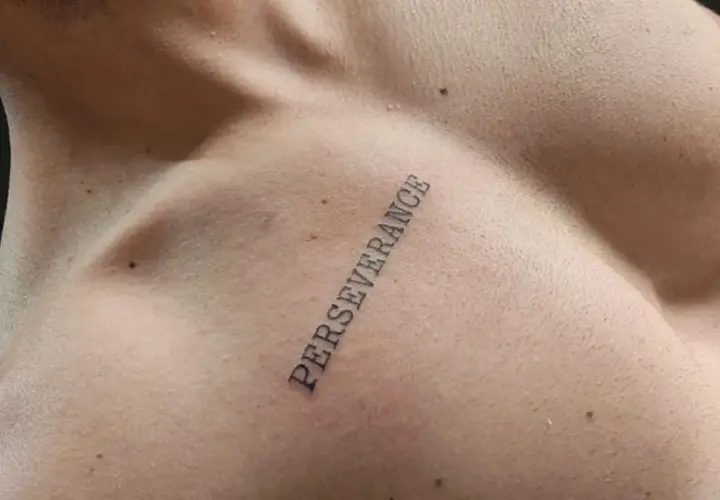 Tatuaż na klatce piersiowej z napisem "PERSEVERANCE" symbolizujący siłę i wytrwałość w dążeniu do celu.