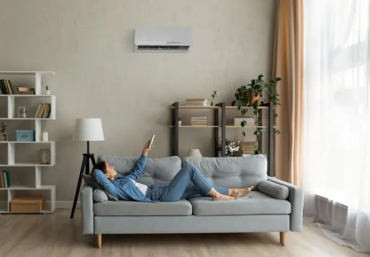 Soggiorno con pareti grigio moderno, divano comodo e aria condizionata. Perfetto per rilassarsi con un libro.