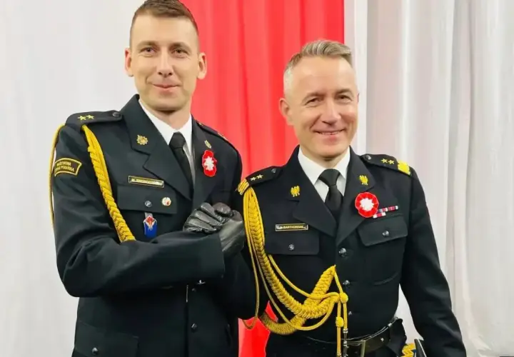 Dwóch mężczyzn w galowych mundurach, z bogatym **uposażeniem**, ściska sobie dłonie.