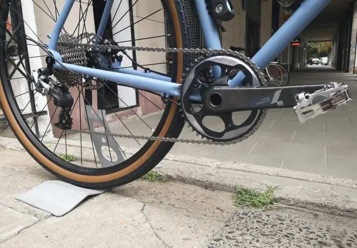 Błękitny rower z napędem Shimano, widok na tylne koło, kasetę i korbę.