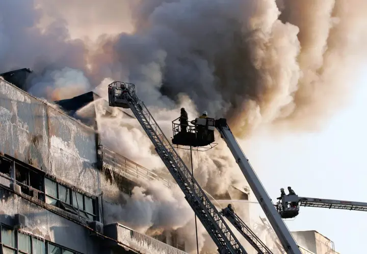 Vigili del fuoco da piattaforme aeree combattono un incendio in un edificio, dimostrando che la lana di roccia è ignifuga.