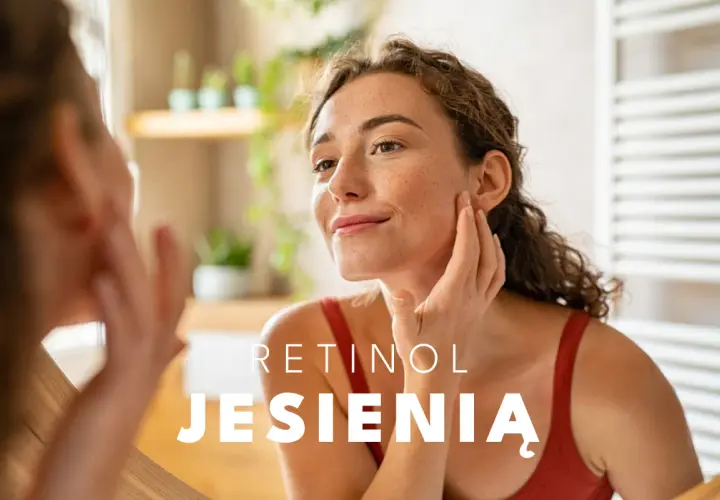 Kobieta z piegami dotyka twarzy, zastanawiając się, jak stosować retinol jesienią.