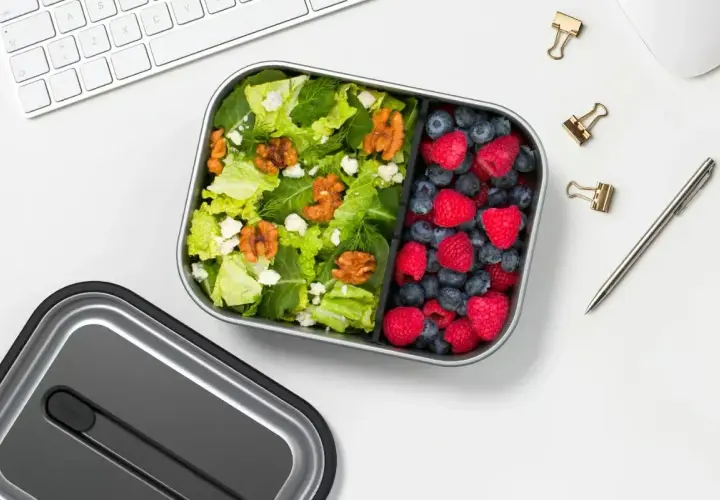 A healthy lunch bento box with a fresh salad and berries, perfect for a desk lunch, not a curry bento box.