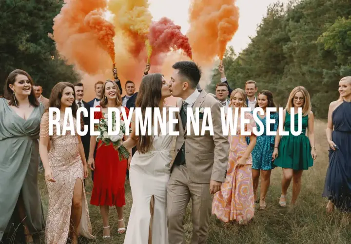 Para młoda całuje się na tle weselnych gości, którzy trzymają race dymne w kolorach tęczy.