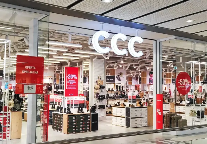 CCC - promocje w sklepach stacjonarnych. W witrynie sklepu CCC widoczne są wyprzedaże -20% i -50% na obuwie i torebki.