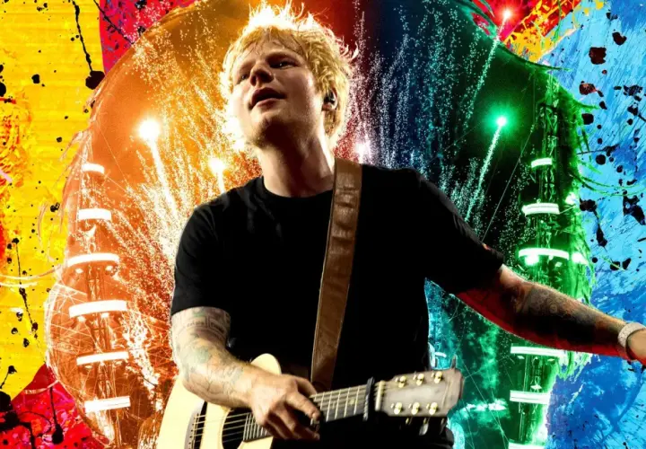 Ed Sheeran gra na gitarze na tle kolorowych eksplozji. Wyobraź sobie, kiedy Ed Sheeran zagra koncert w Polsce!