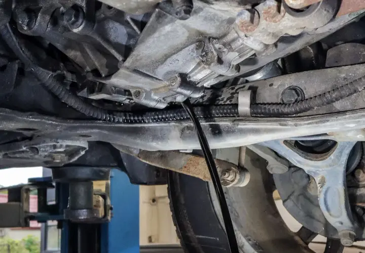 Podczas wymiany oleju w skrzyni manualnej, czarny pręt wchodzi do mechanizmu, by spuścić zużyty płyn.