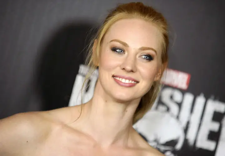Deborah Ann Woll, qui a joué Karen Page, souriant devant le logo de The Punisher.
