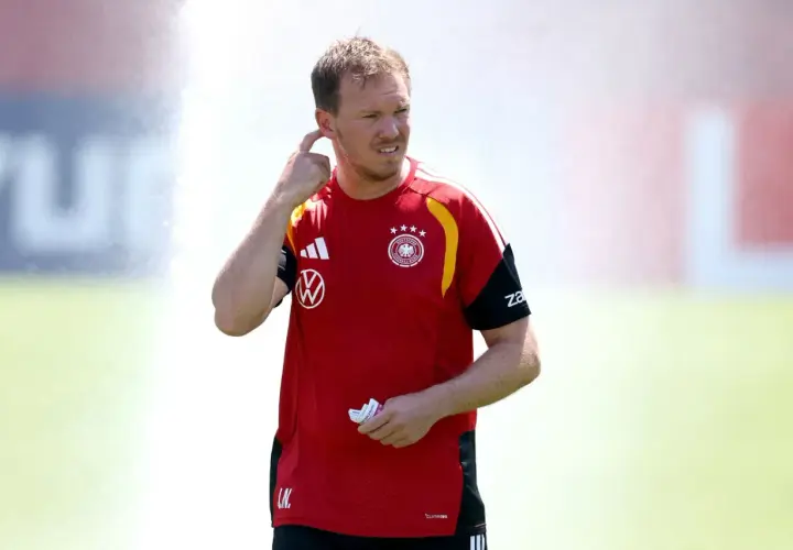 Trener reprezentacji Niemiec, Julian Nagelsmann, w czerwonej koszulce z godłem DFB, gestykuluje podczas treningu.