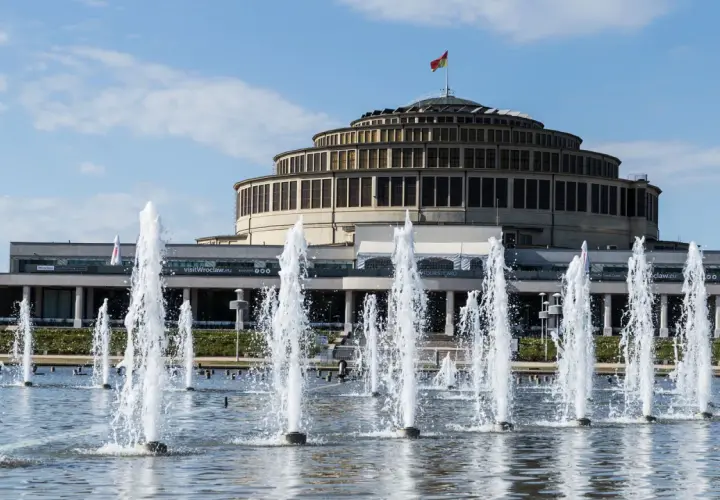 Wrocławska Hala Stulecia, jeden z obiektów UNESCO w Polsce, z fontannami w letni dzień.