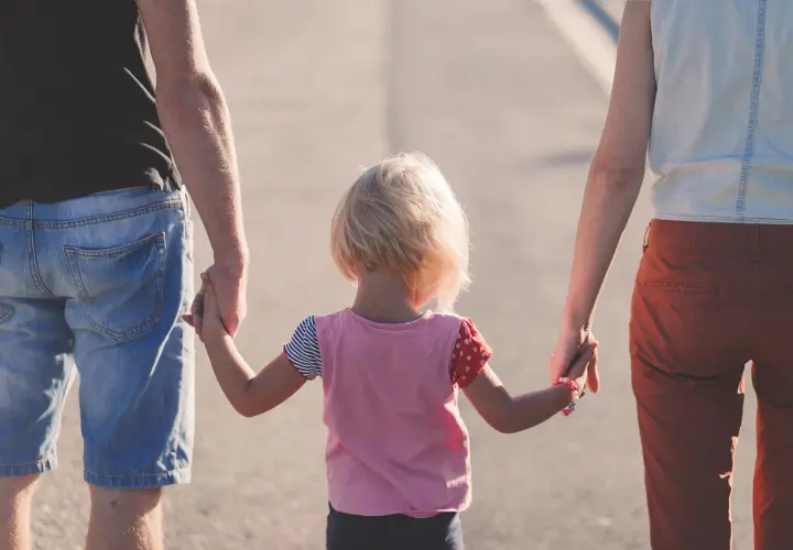 Rodzina idzie razem. Dziecko trzyma za ręce kobietę i mężczyznę, tworząc piękny związek z kobietą z dzieckiem.
