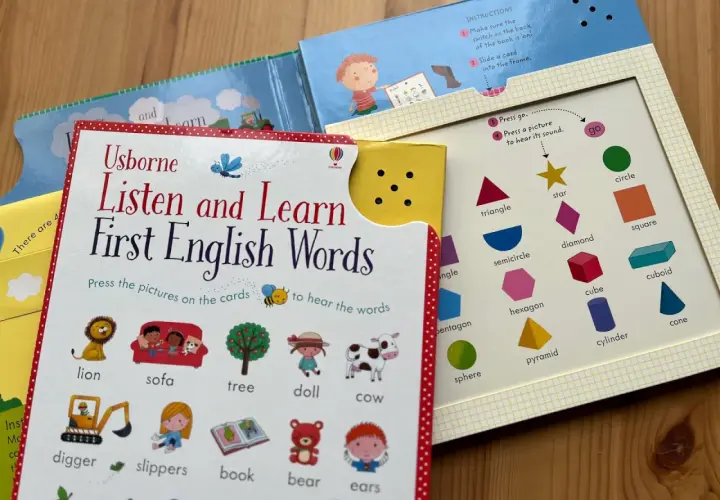 Książka "Listen and Learn First English Words" zachęca do nauki słówek po angielsku. Na kartach są obrazki zwierząt, przedmiotów i kształtów.