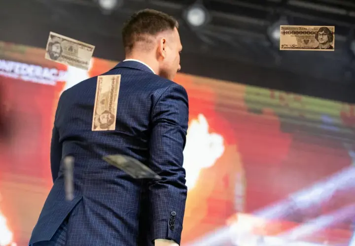 Mężczyzna w garniturze z banknotami na plecach. To wizualizacja programu partii politycznej przykłady, pokazująca inflację.
