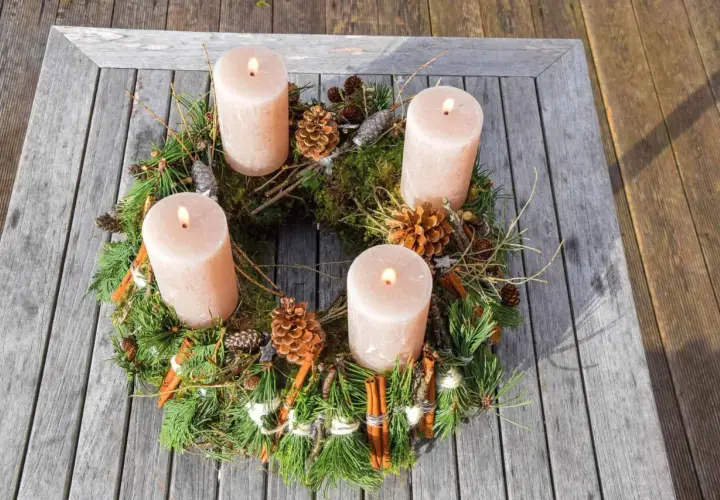 Natürlicher Adventskranz mit vier Kerzen, Tannenzweigen, Zapfen und Zimtstangen. Tolle Adventskranz Ideen für ein gemütliches Zuhause.