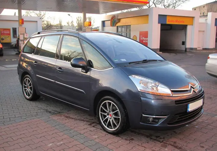 Ciemnoszary Citroen C4 Grand Picasso 2.0 HDI na tle stacji paliw.