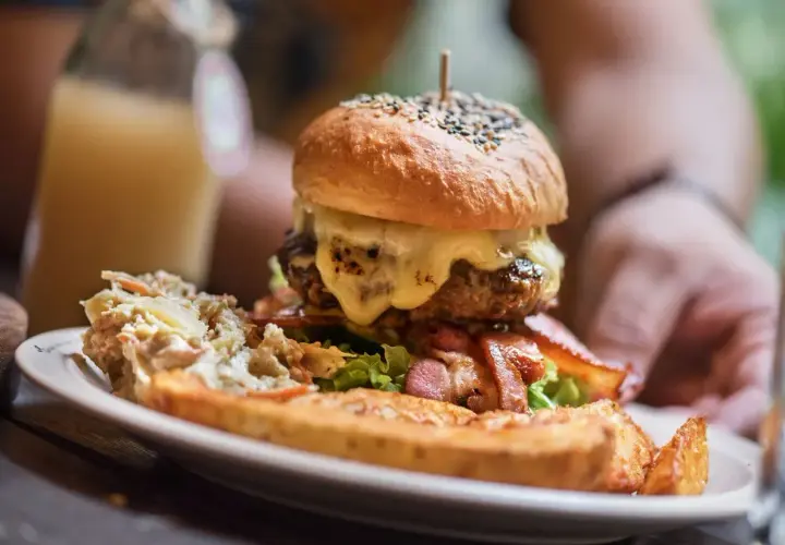 Ogromny burger z rozpływającym się serem, chrupiącym boczkiem i surówką. Wygląda jak posiłek dla prawdziwego drwala!