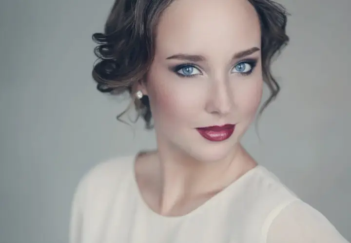 Maquillaje para vestido blanco: ojos ahumados, labios rojos y peinado recogido.