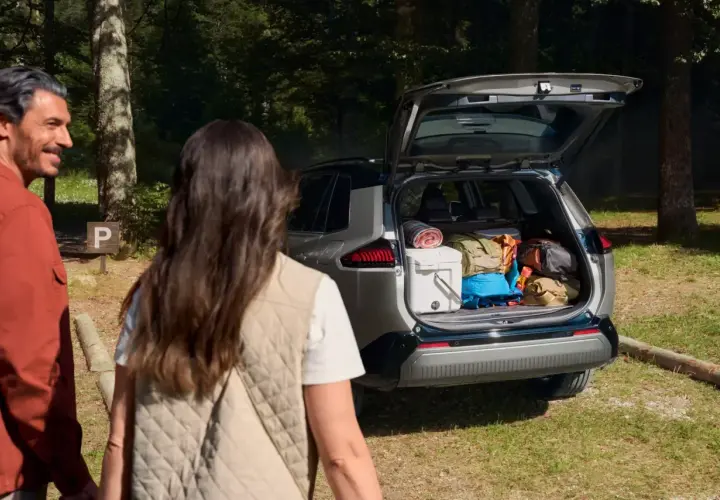 Para wyładowuje bagażnik Toyoty RAV4, gotowa na przygodę. Wymiary bagażnika pozwalają na spakowanie wszystkiego.