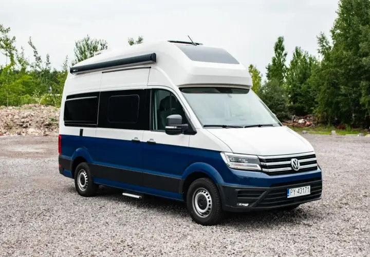 Nowoczesna produkcja kamperów: biało-niebieski Volkswagen Crafter z zabudową kempingową, gotowy na przygody.