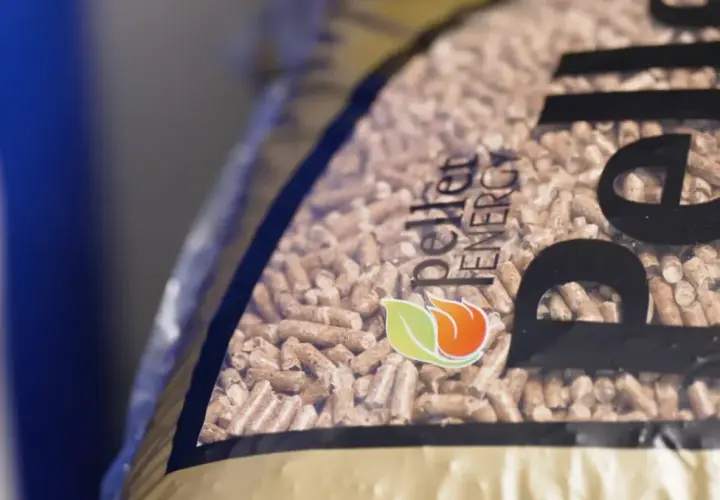 Zbliżenie na worek z pelletem drzewnym. Logo "Pellet Energy" i płomień z liściem. Dowiedz się, jak zrobic pellet.