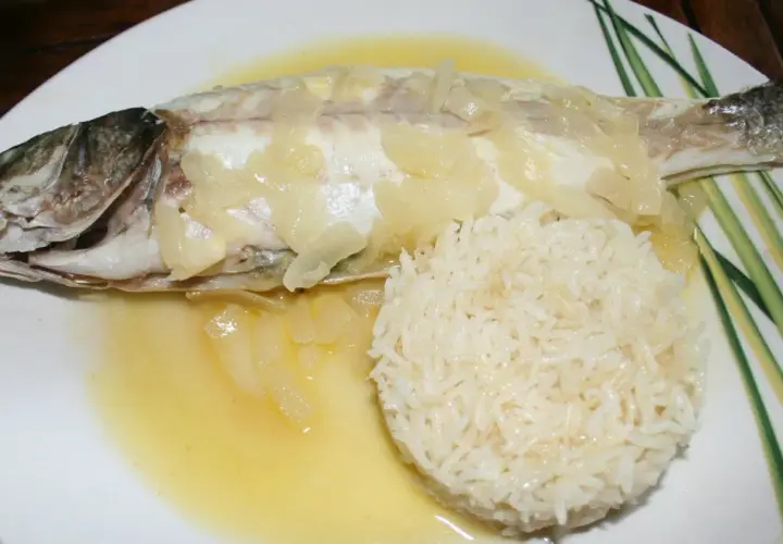 Un délicieux filet de loup au four, nappé d'une sauce au vin blanc et accompagné de riz.