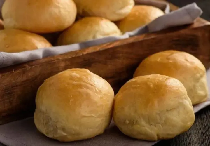 Pan de cebolla recién horneado, dorado y esponjoso, servido en una cesta de madera.