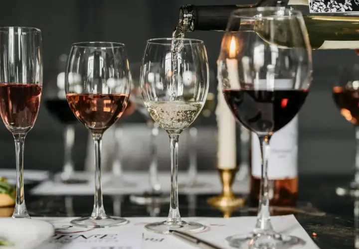 Degustacja win: ile kalorii ma kieliszek białego wina, a ile czerwonego i różowego? Kieliszki z winem białym, różowym i czerwonym na stole.