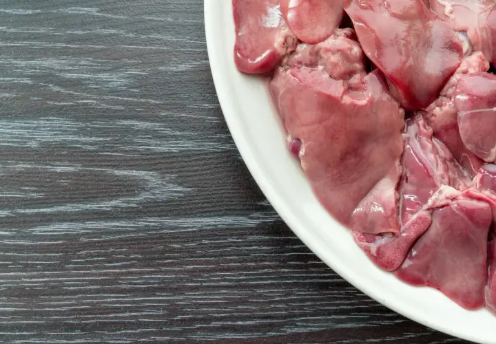 Piatto bianco con durelli di pollo crudi, pronti per essere cucinati.