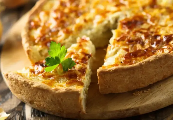 Une quiche dorée, garnie de persil, prête pour la conservation au frigo. Parfaite pour un repas rapide.