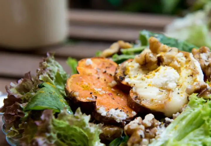 Deliciosa ensalada de batata asada con queso de cabra cremoso, nueces crujientes y hojas verdes frescas.