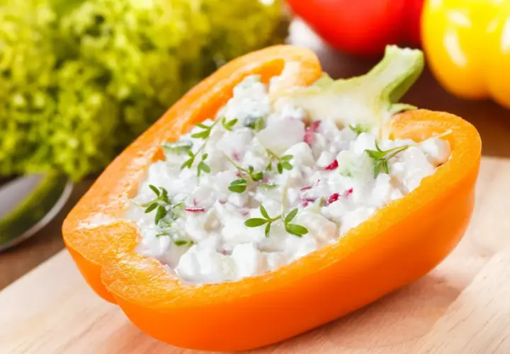 Pomarańczowa papryka faszerowana twarożkiem i ziołami. Papryka właściwości odżywcze czynią ją idealną bazą dla zdrowych przekąsek.
