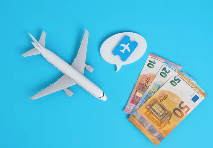 Avión de juguete, billetes de euro y un ticket aéreo. Piensa en cuándo es mejor comprar vuelos para ahorrar.