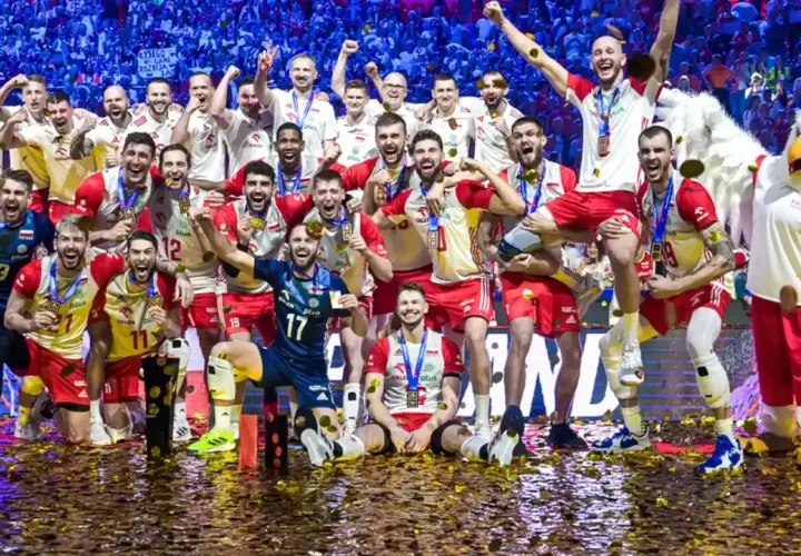 Radosna drużyna siatkarzy świętuje, kiedy Polska była mistrzem świata w siatkówce. Konfetti i maskotka orła dopełniają scenę triumfu.