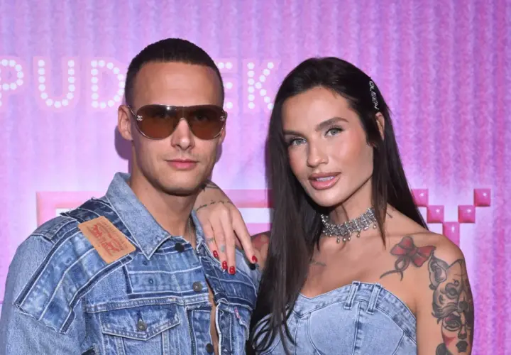 Mateusz Świerczyński z Love Island w dżinsowej kurtce i jego partnerka z naszyjnikiem na tle różowej ściany.